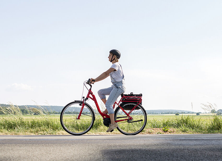 Auf dem Rad durch die Landschaft - bei Hitze lieber schattige Route auswählen Person auf dem Fahrrad auf der Landstraße