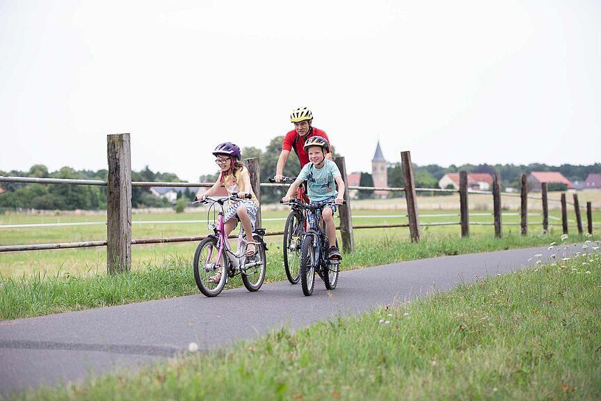 Opa mit Kindern auf Radtour Opa mit zwei Kindern auf Fahrradweg im ländlicher Umgebung